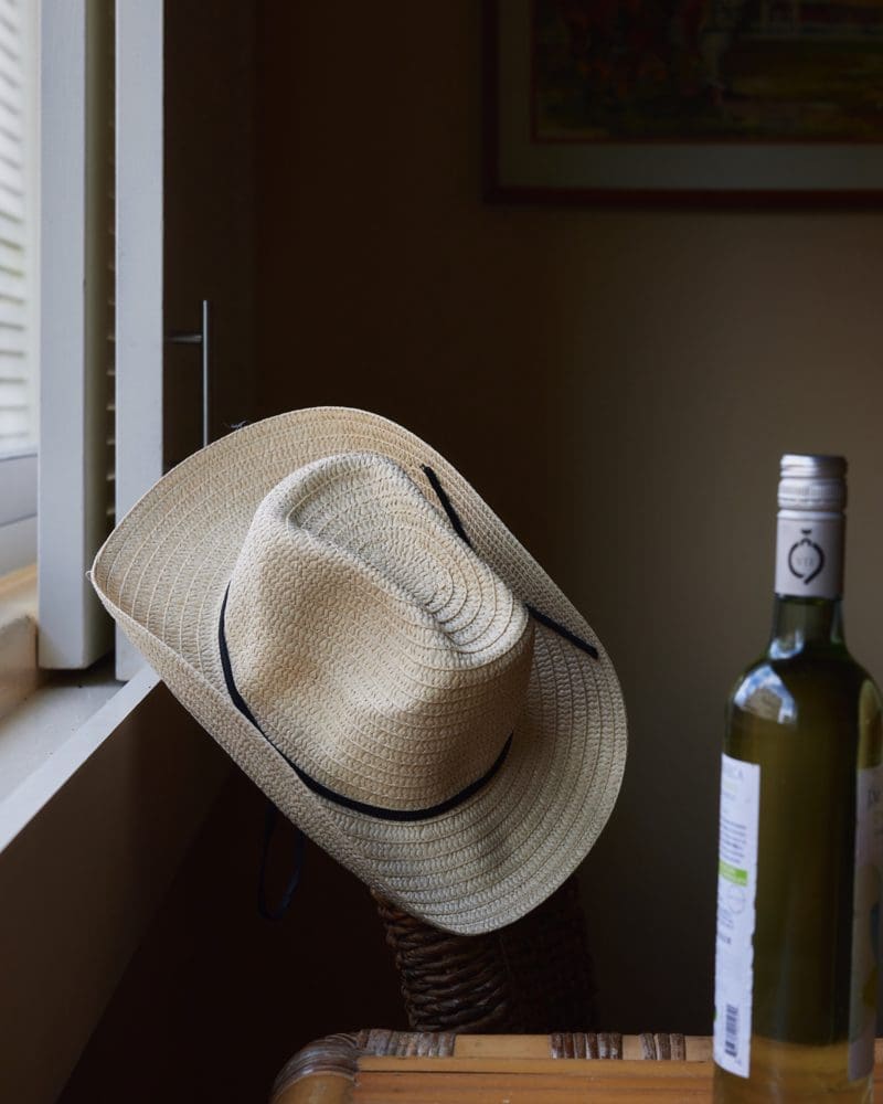 A straw hat hung by the window of a guest room at The Equus
